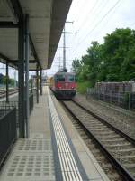 Hier durchf�hrt eine Re 4/4 mit einem aufgebocktem Bahndienstfahrzeug den Bahnhof Sch�nb�hl SBB